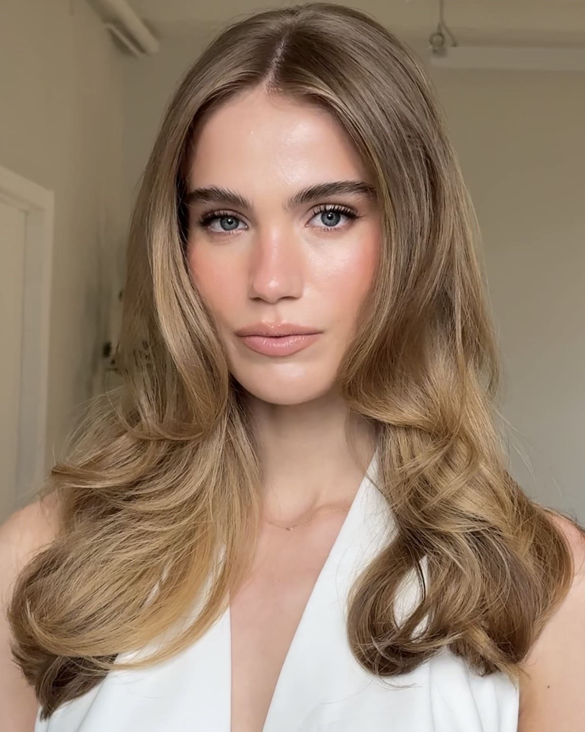 a blonde bride with a layered hairstyle poses for the camera, layered is a top 2026 hair trend!