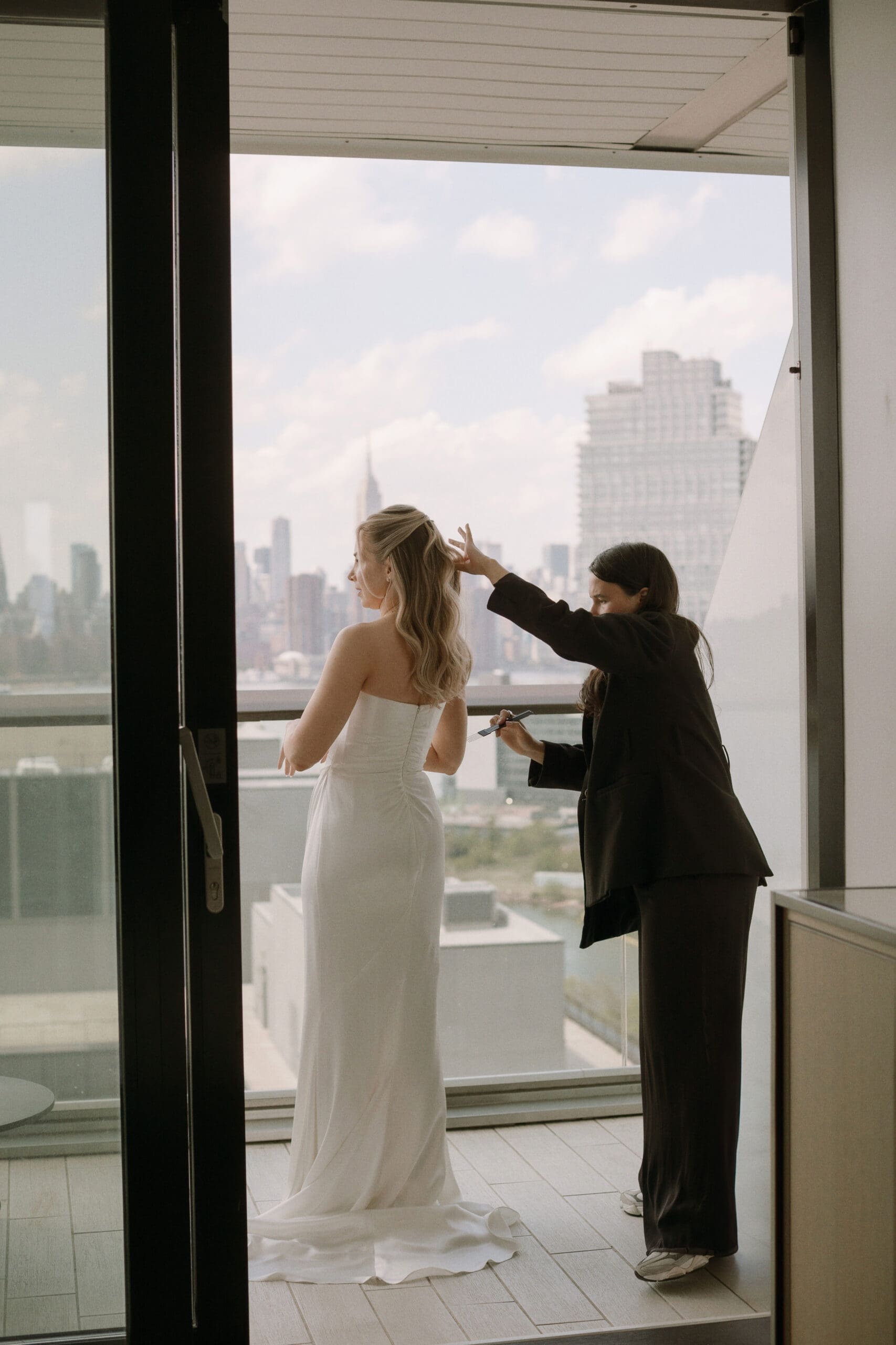Sophie adds the final touches on the stunning blonde brides hair as they finish their preparation for the NYC wedding day