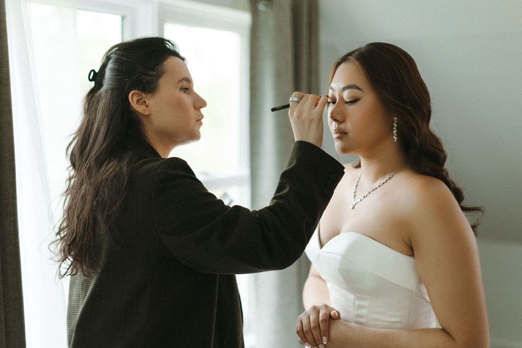 bride gets her makeup prepped for her wedding day during her bridal beauty timeline by SM Beauty.