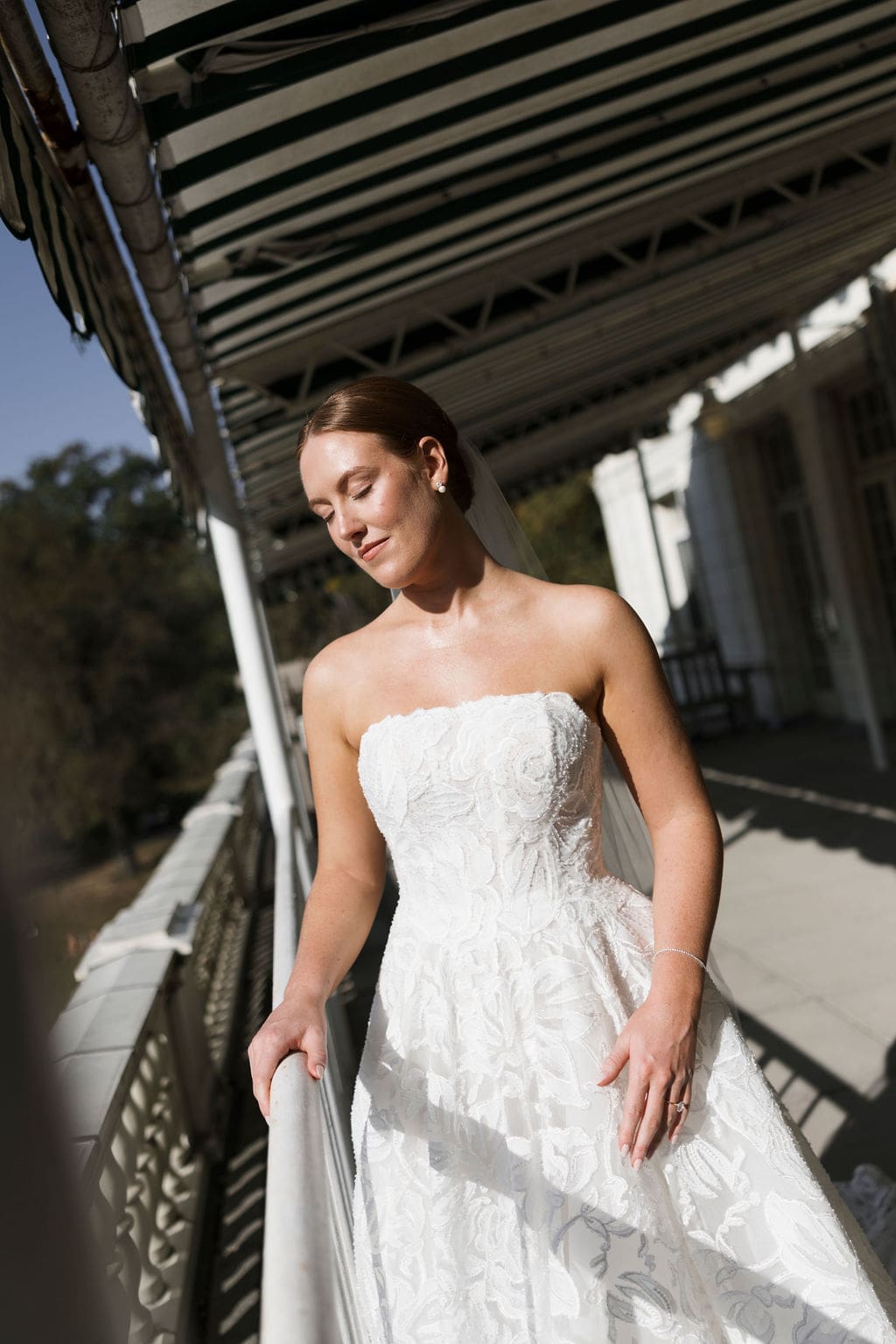 bride poses for a photo by the water
